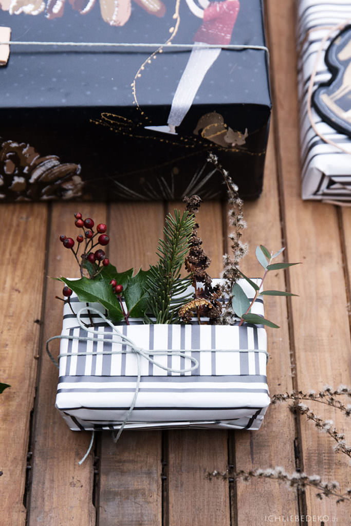 natuerliche Weihnachtsgeschenkverpackung mit Tannen und Beeren