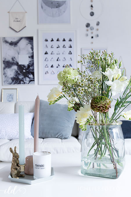 wilder-blumenstrauss-und-moderne-kerzen-im-wohnzimmer-im-skandi-stil